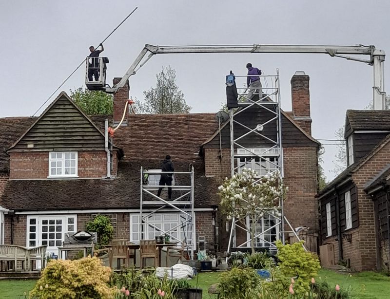 The Roof Moss Cleaners using cherry picker and scaffolding to clean roof safely and professionally in Ashtead, Surrey